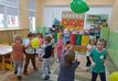 Dziewczynki i chłopcy z grupy Misie podbijają zielony, żółty balon.